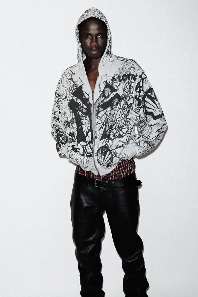 Homme en sweat à capuche imprimé et pantalon en cuir.