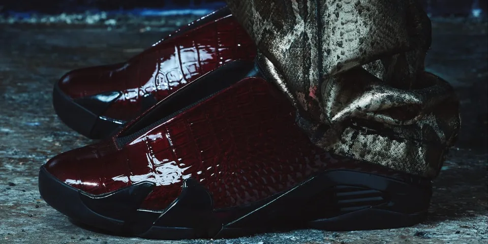 Chaussures en cuir rouge foncé avec pantalon à motif, sol en béton.