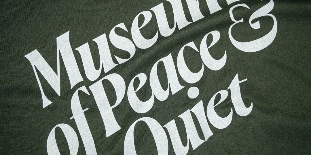 Texte blanc « Musée de la paix & Quiet » sur fond vert sombre texturé.