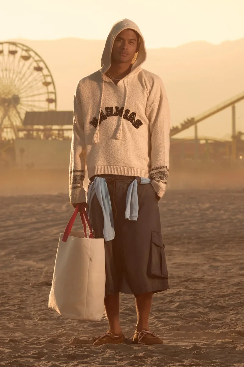 Homme en tenue décontractée sur une plage au coucher du soleil.