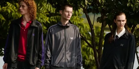 Trois personnes posant en vêtements de sport sous des arbres.