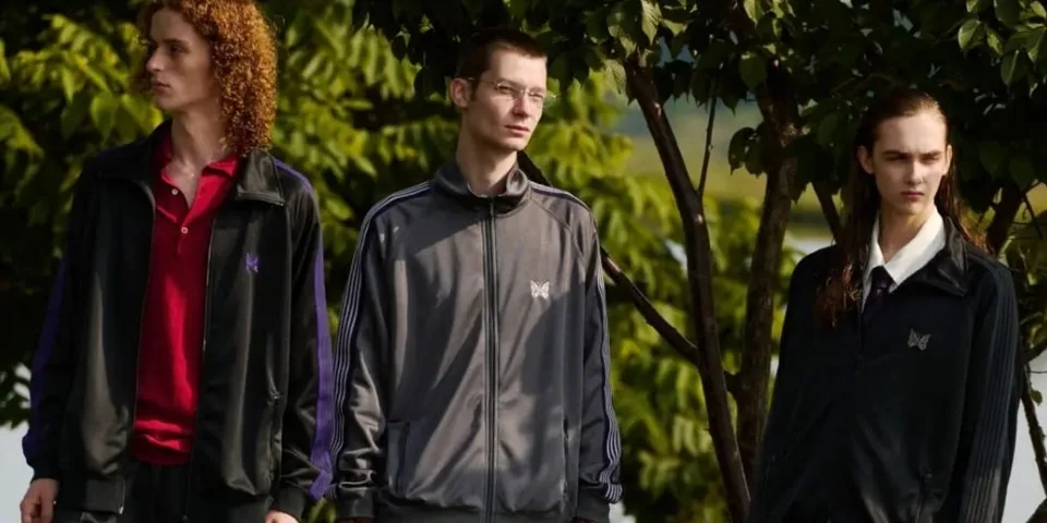 Trois personnes posant en vêtements de sport sous des arbres.