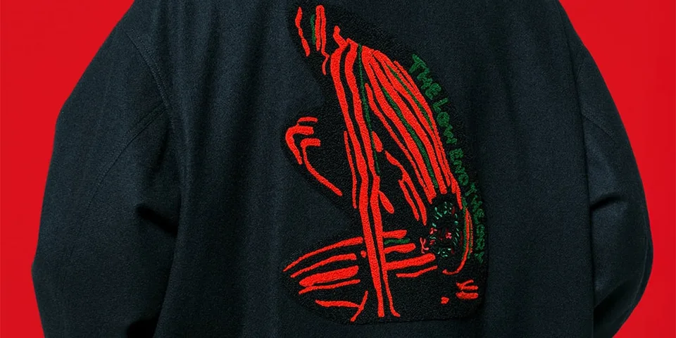 Personne avec veste noire et motif rouge et vert sur fond rouge.