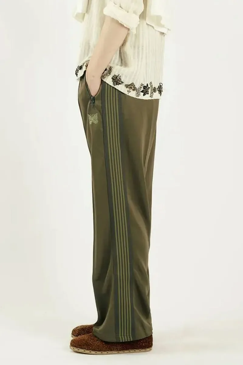 Personne portant un pantalon vert avec papillon et bandes latérales