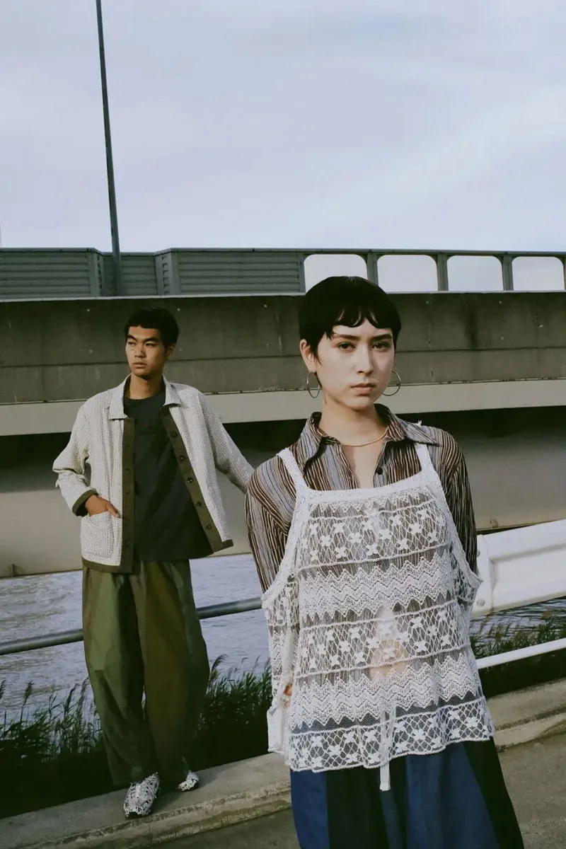 Deux personnes posant sur un pont avec des vêtements modernes.