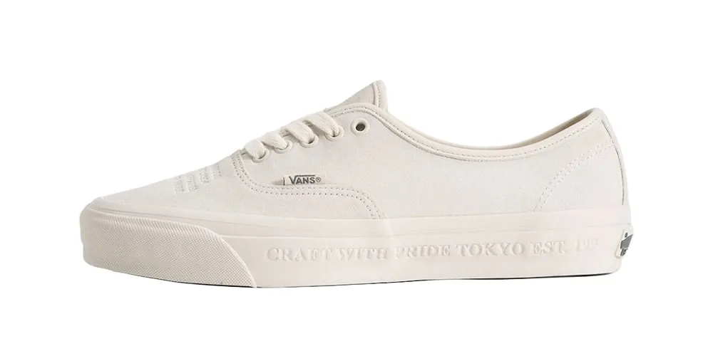 Chaussure blanche Vans avec texte sur la semelle.