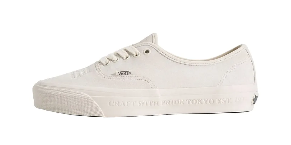Chaussure blanche Vans avec texte sur la semelle.