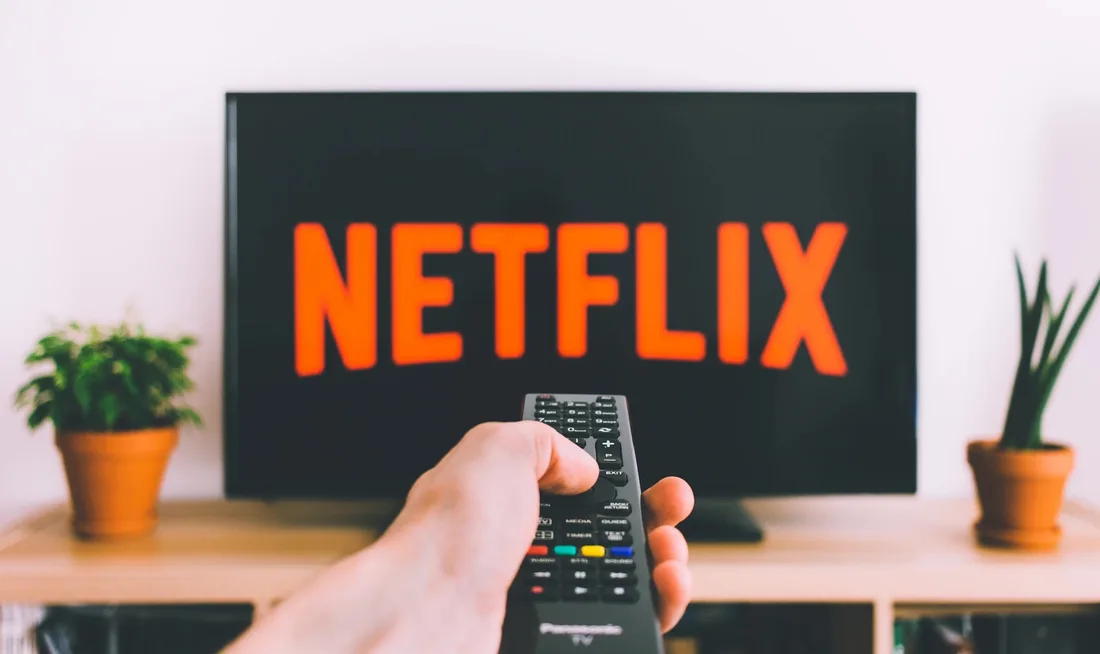 Télécommande pointée vers un écran affichant le logo Netflix.