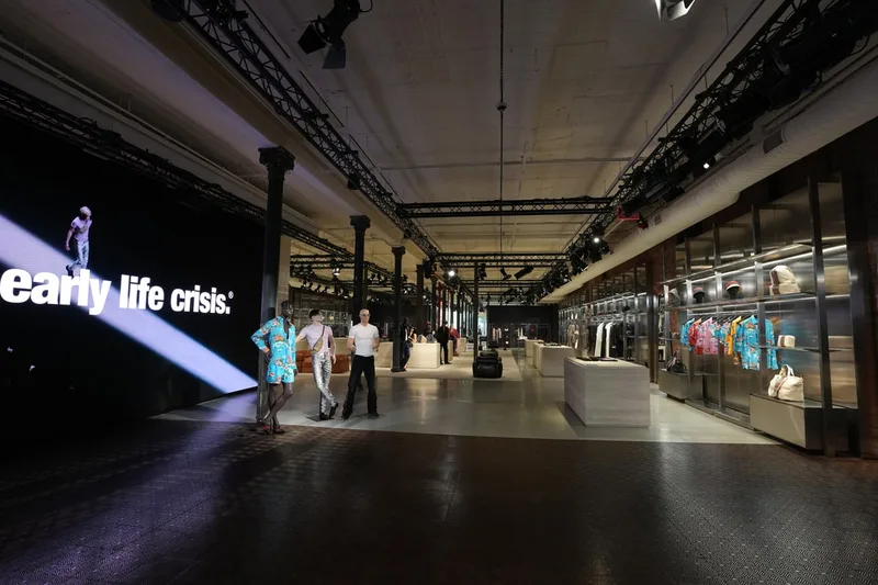 Intérieur moderne avec affichage lumineux et mannequins, vêtements exposés.