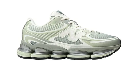 Chaussure de sport gris et blanc avec semelle épaisse et détails verts.