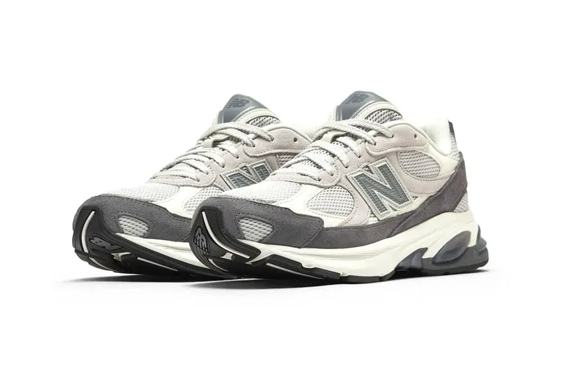 Chaussures de sport New Balance grises et blanches, vue de trois quarts.