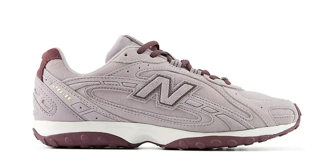 Chaussure de sport New Balance violette et beige avec logo 'N' sur le côté.