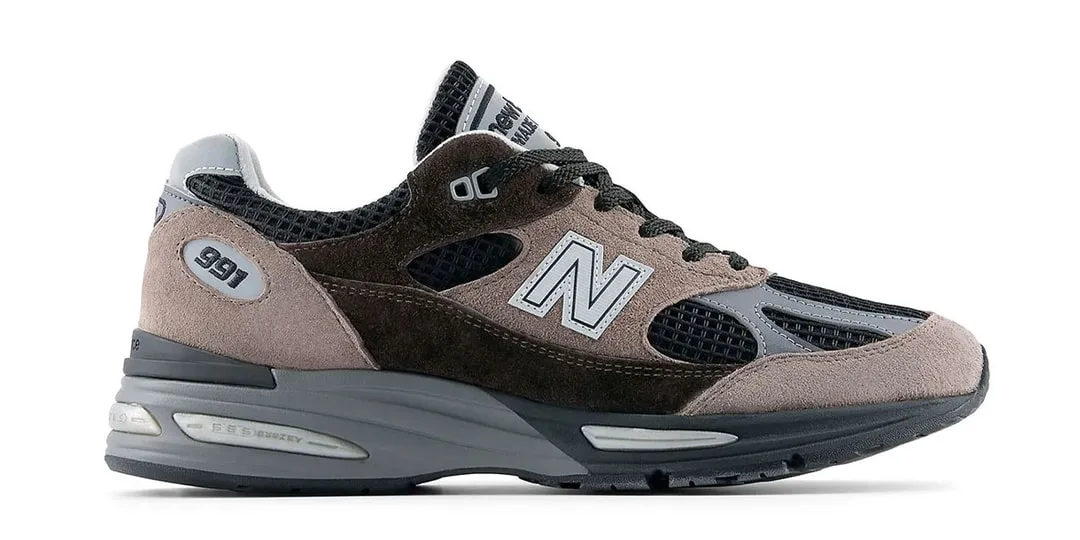 Basket New Balance grise et noire avec détails en daim et semelle épaisse.