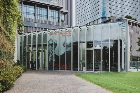 Bâtiment moderne avec affiches en verre et pelouse verte à l'avant.