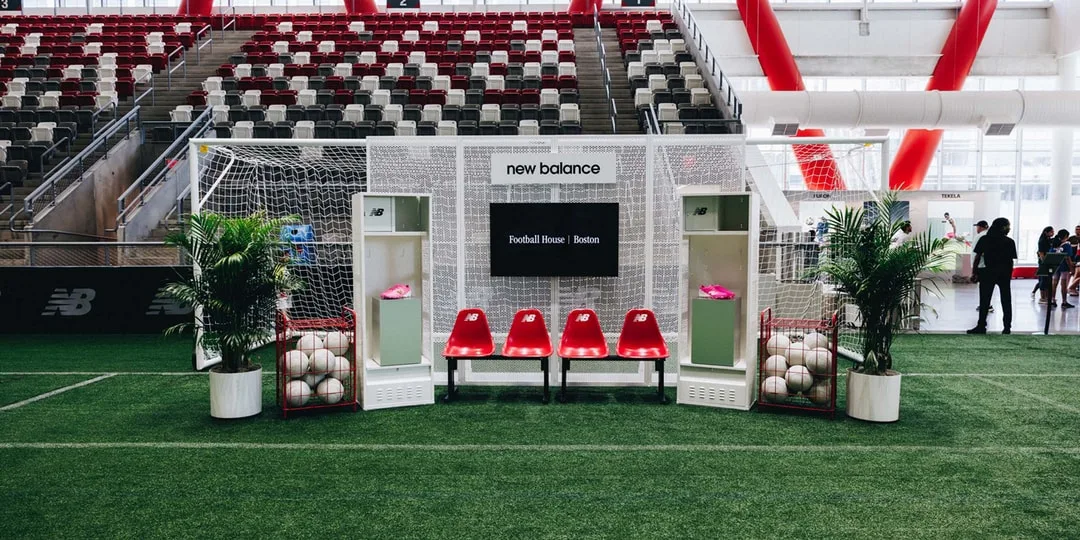 Terrain de foot avec sièges, ballons et casiers New Balance.