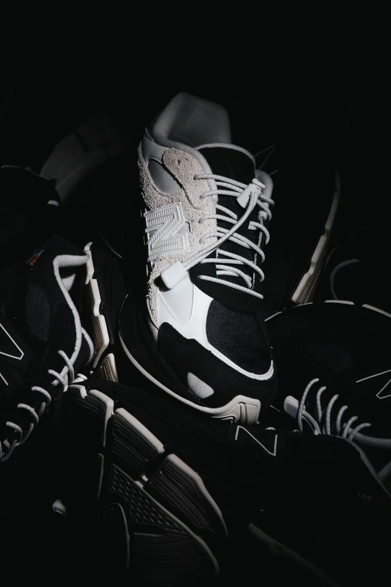 Chaussures noires et blanches en gros plan sur fond sombre.
