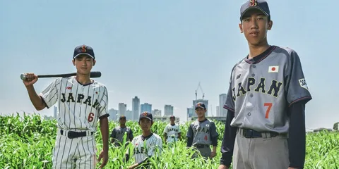 Jeunes joueurs de baseball japonais avec une ville en arrière-plan.