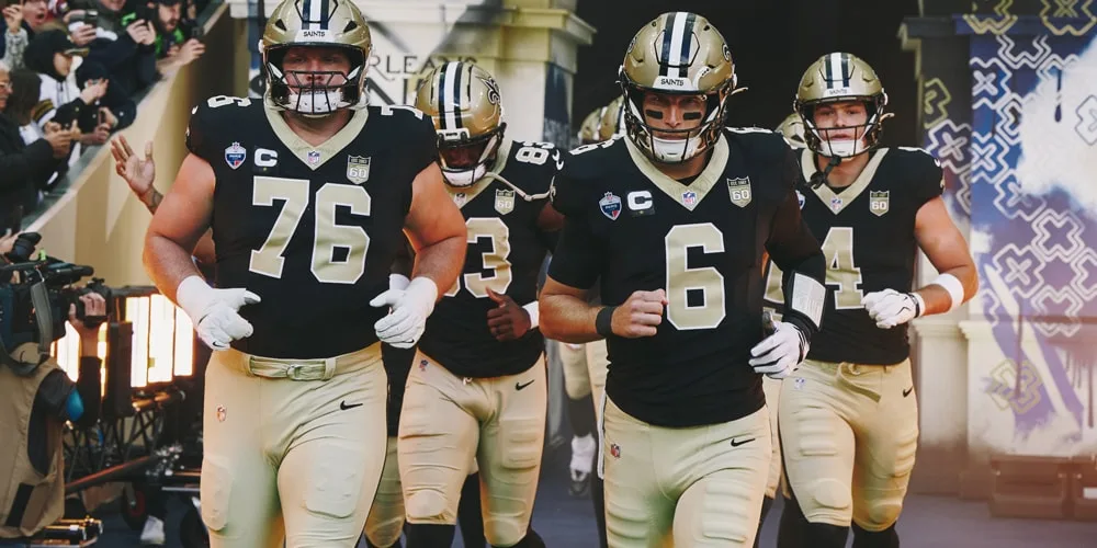 Des joueurs de football américain des Saints de La Nouvelle-Orléans entrent sur le terrain.
