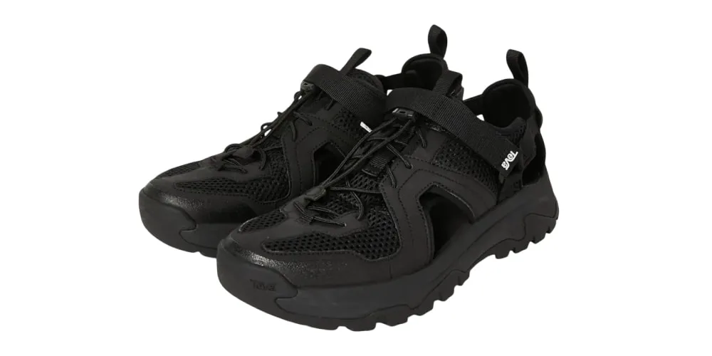 Chaussures noires avec lacets et semelles épaisses en maille et cuir synthétique.