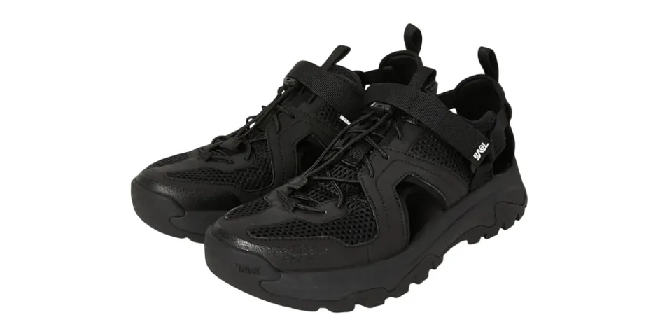 Chaussures noires avec lacets et semelles épaisses en maille et cuir synthétique.