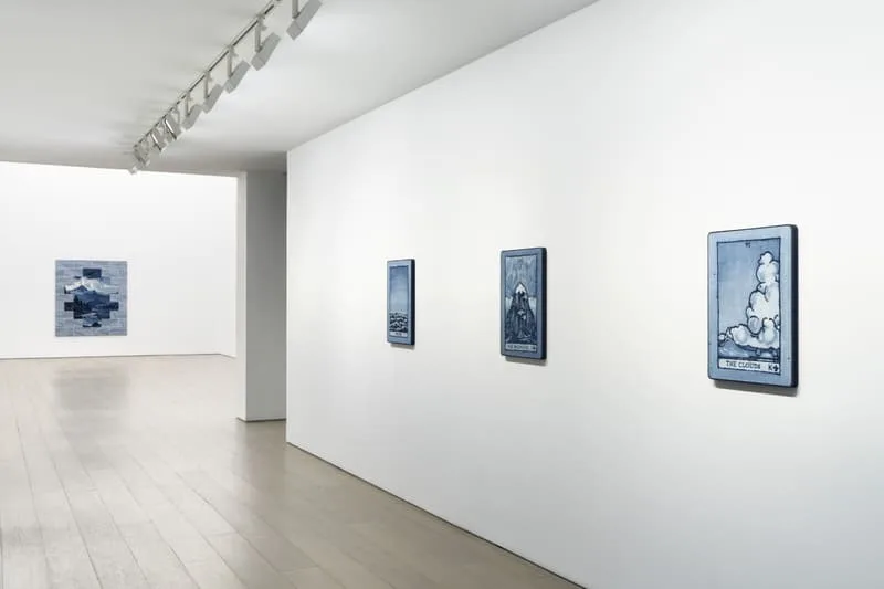 Galerie d'art avec peintures bleues sur les murs blancs.