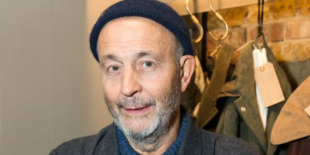 Homme portant un bonnet bleu, manteaux en arrière-plan.