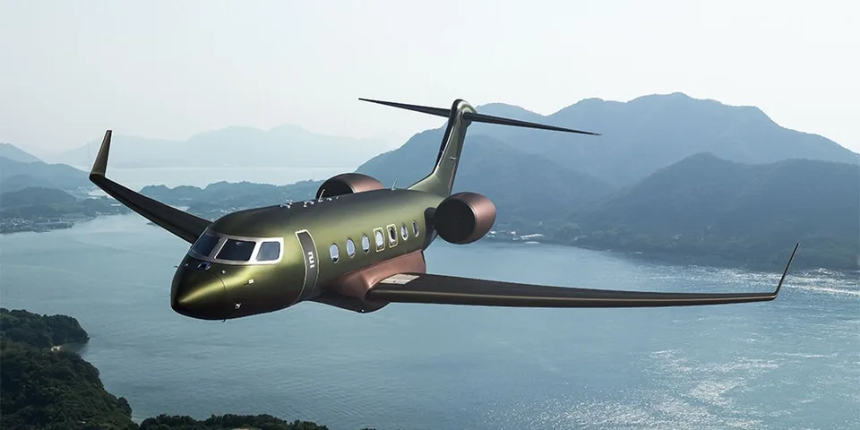 Avion privé de luxe en vol au-dessus des montagnes et d'un lac.