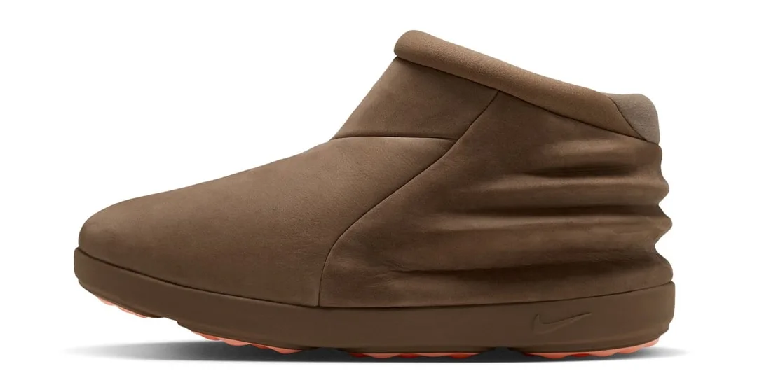 Chaussure marron avec design unique, semelle orange.