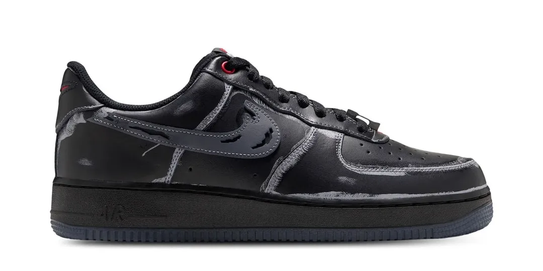 Chaussure noire Nike avec motif artistique blanc, design moderne.