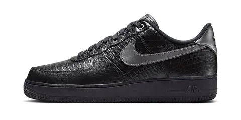 Chaussure noire avec motif texturé et logo Swoosh argenté.