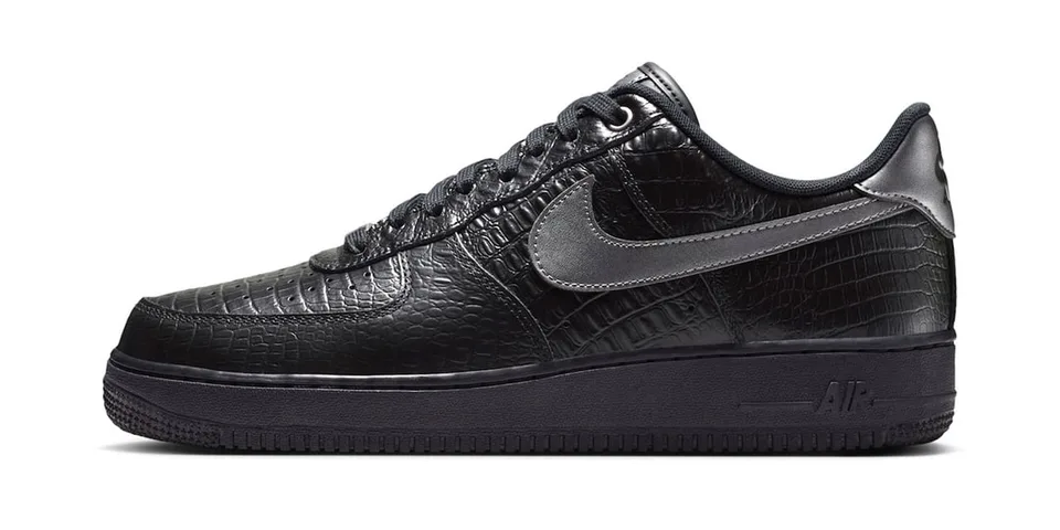 Chaussure noire avec motif texturé et logo Swoosh argenté.