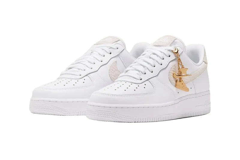 Chaussures de sport blanches avec détail doré sur le côté.