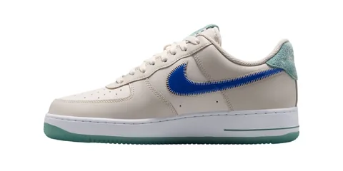 Chaussure beige avec logo bleu et semelle verte.
