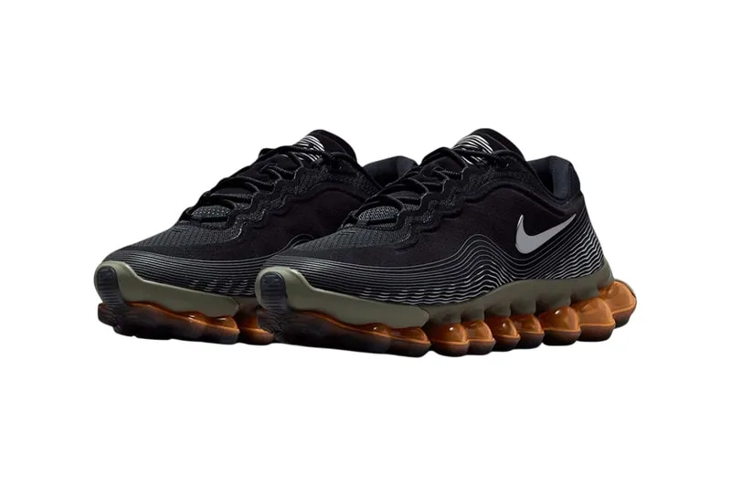 Chaussures noires avec semelles oranges et logo blanc.