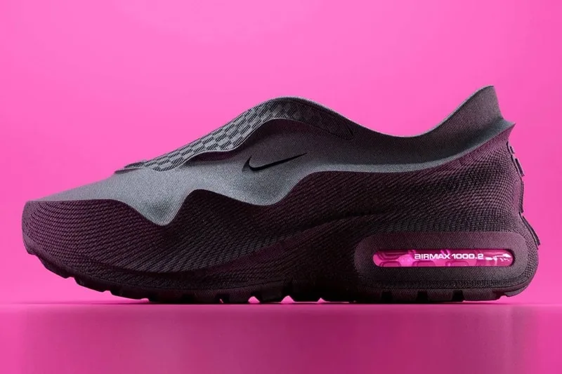 Chaussure noire sur fond rose avec semelle visible.