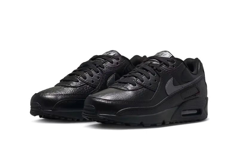 Chaussures de sport noires avec détails en relief et logo argenté.