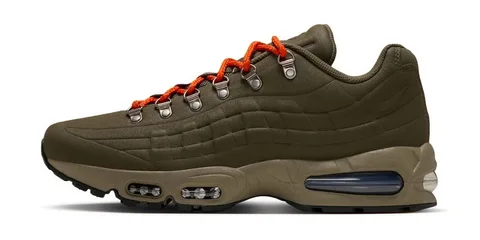 Chaussure de sport olive avec lacets orange et œillets métalliques.