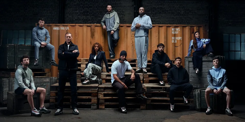 Groupe de personnes posant en vêtements de sport dans un entrepôt.