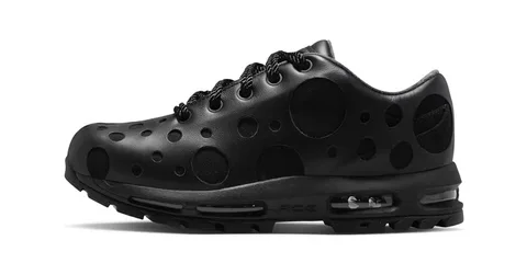 Chaussure noire à trous ronds sur le côté, semelle visible.