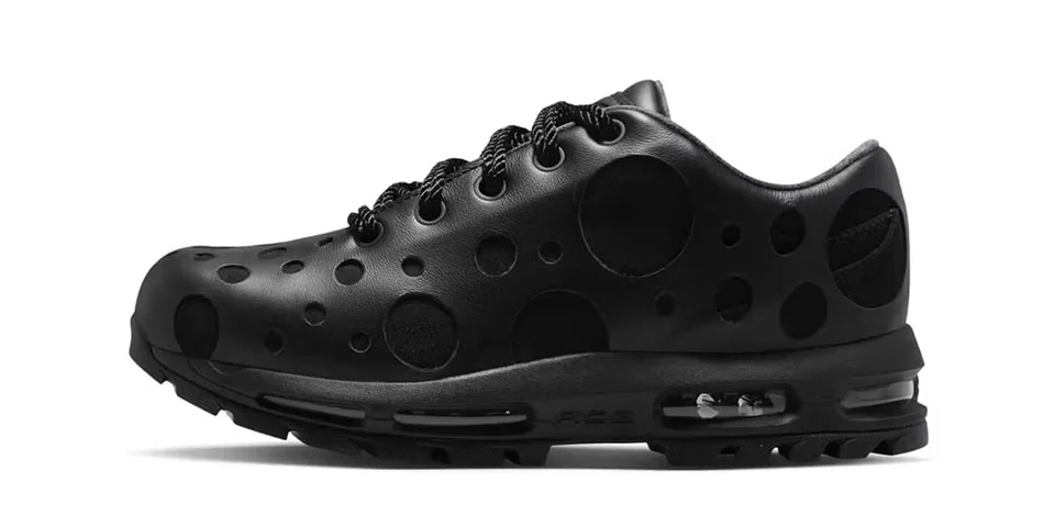 Chaussure noire à trous ronds sur le côté, semelle visible.