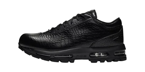 Chaussure noire avec motif imitation peau de crocodile et semelle épaisse.