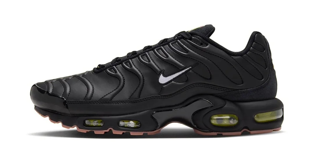 Chaussure de sport noire avec des détails en relief et semelle visible.