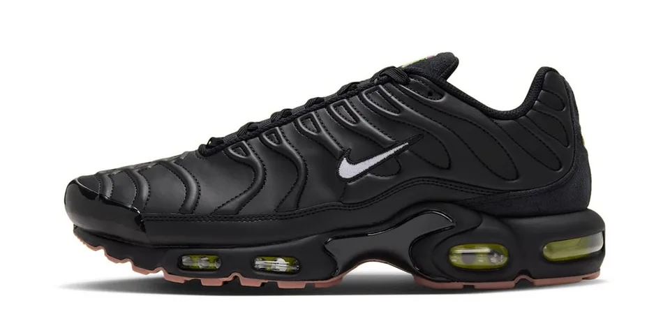 Chaussure de sport noire avec des détails en relief et semelle visible.