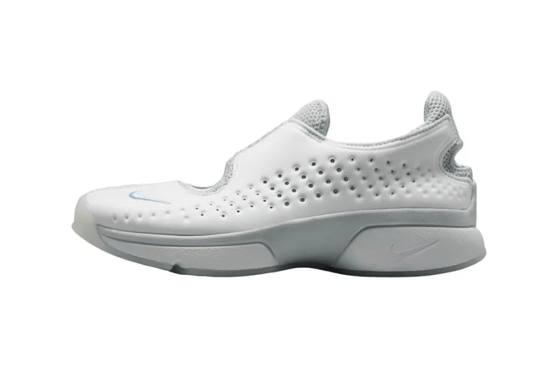 Chaussure blanche minimaliste avec perforations et logo bleu.
