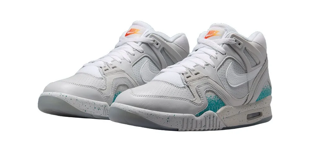 Chaussures de sport blanches avec accents bleu et orange.