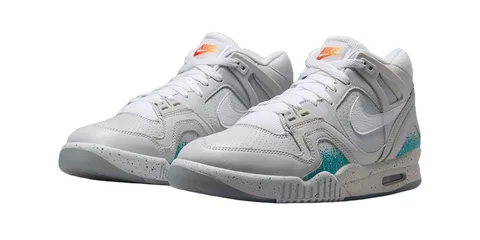 Chaussures de sport blanches avec accents bleu et orange.