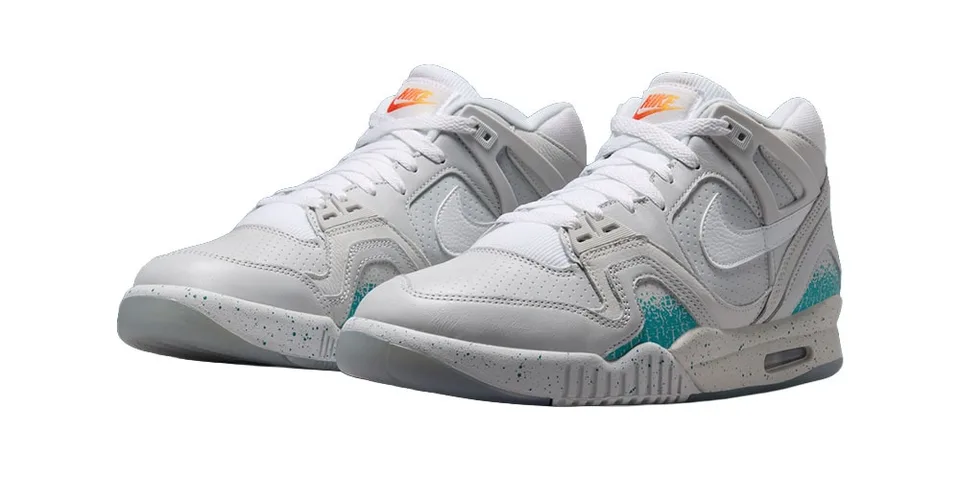 Chaussures de sport blanches avec accents bleu et orange.