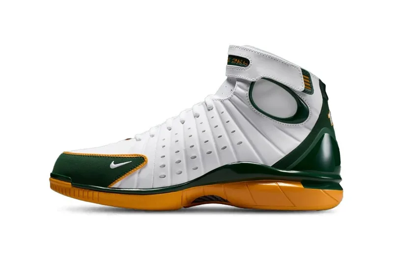 Chaussure de sport blanche et verte avec semelle orange.