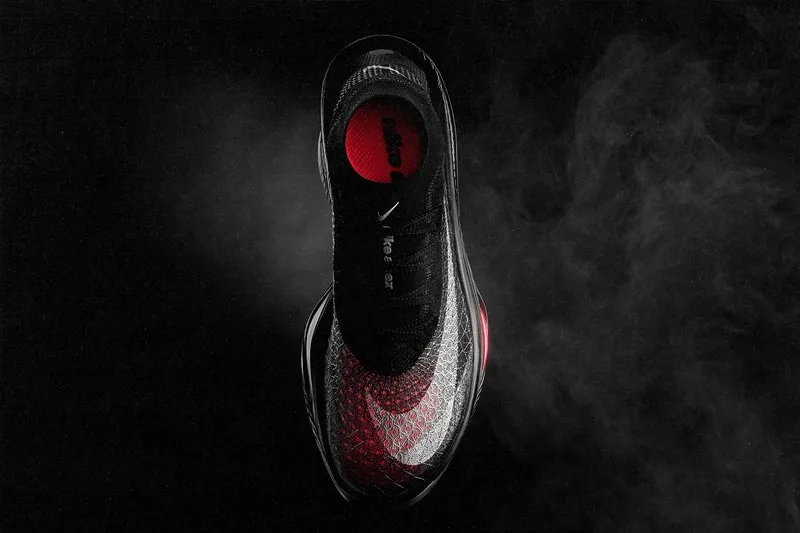 Chaussure noire et rouge sur fond sombre avec de la fumée.