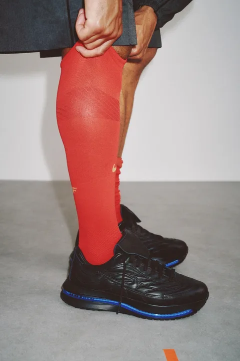 Homme portant chaussettes rouges et baskets noires.